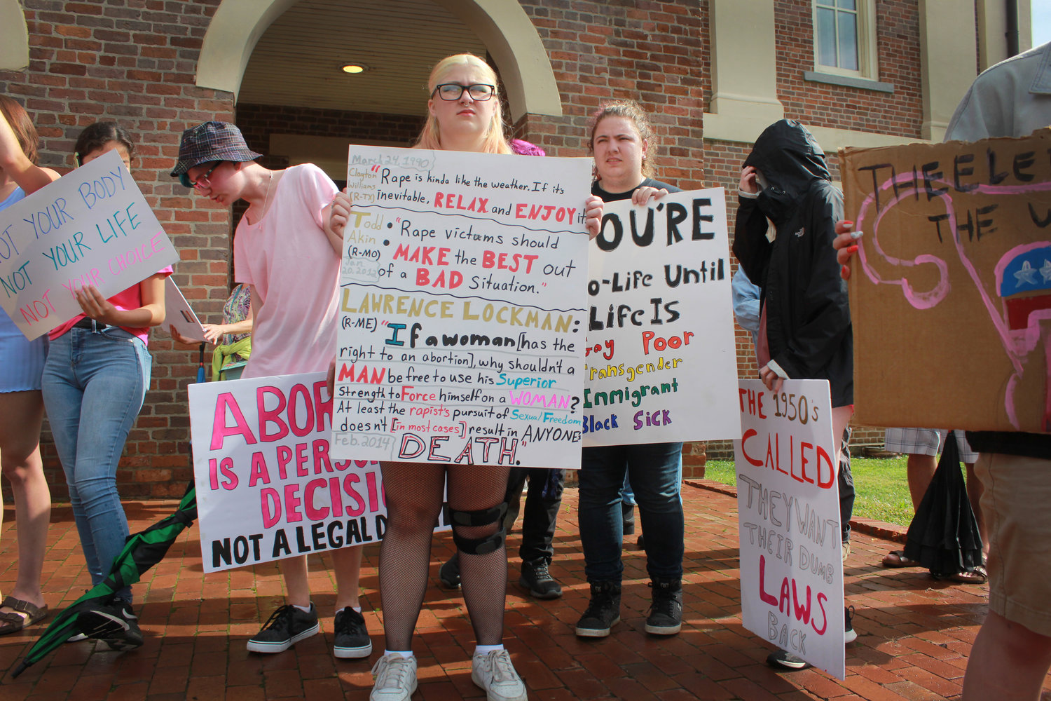 Protesters hold signs outside of the Pittsboro Historic Courthouse  during the abortion and women’s rights protest on Monday in Pittsboro. Dozens of people gathered at the courthouse as a reaction to the overturning of Roe v. Wade.
